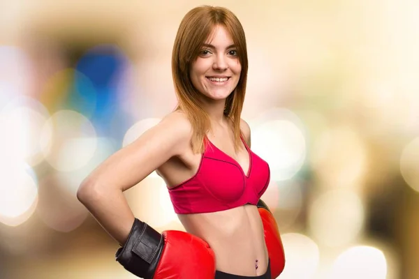 Jovem mulher esporte com luvas de boxe em fundo desfocado — Fotografia de Stock