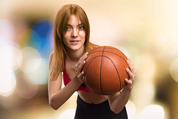 Jovem mulher do esporte com bola de basquete em fundo desfocado — Fotografia de Stock