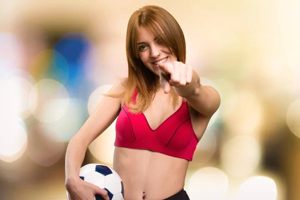 Young sport woman  holding a soccer ball on unfocused background — Stock Photo, Image
