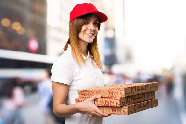 Pizza delivery woman  on unfocused background