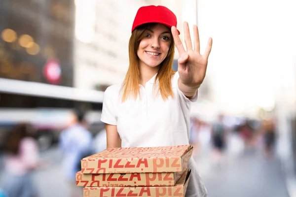 Доставка пиццы женщина рассчитывает четыре на несосредоточенном фоне — стоковое фото