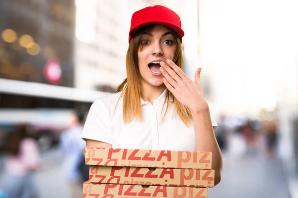 Разносчица пиццы делает неожиданный жест на несконцентрированном бэкге — стоковое фото