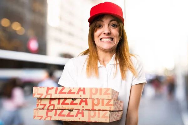 Разносчица пиццы кричит на несобранном фоне — стоковое фото