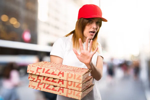 Frightened pizza delivery woman  on unfocused background