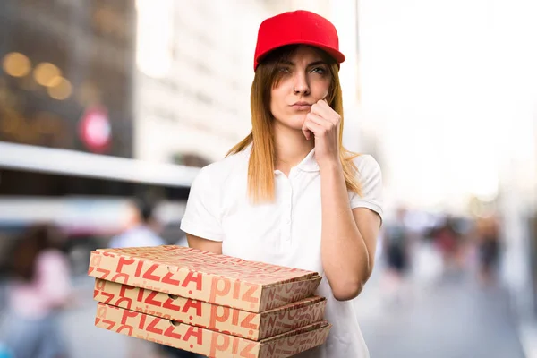 Pizza entrega mujer pensando en fondo desenfocado —  Fotos de Stock