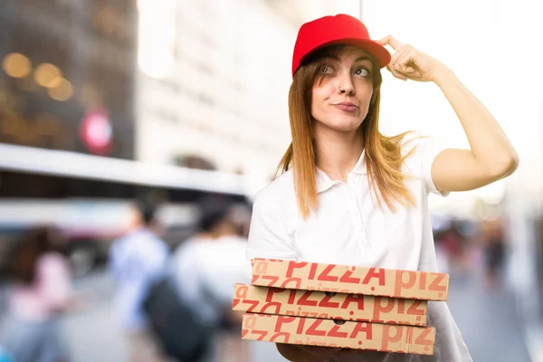 Доставка пиццы женщина с сомнениями на несосредоточенном фоне — стоковое фото