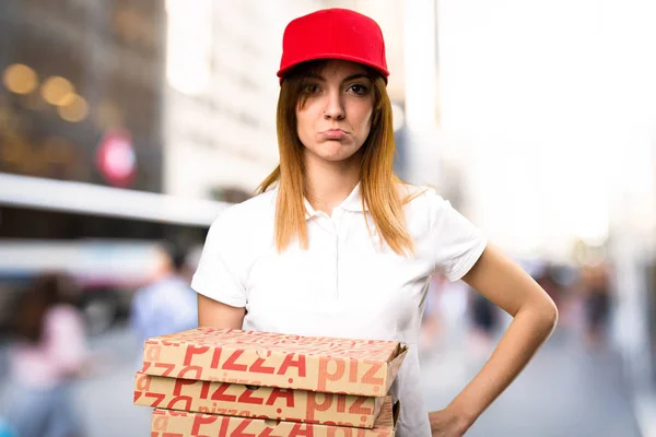 Грустная разносчица пиццы на неориентированном фоне — стоковое фото