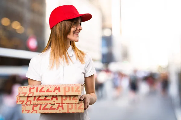 Доставка пиццы женщина смотрит в сторону на несосредоточенном фоне — стоковое фото