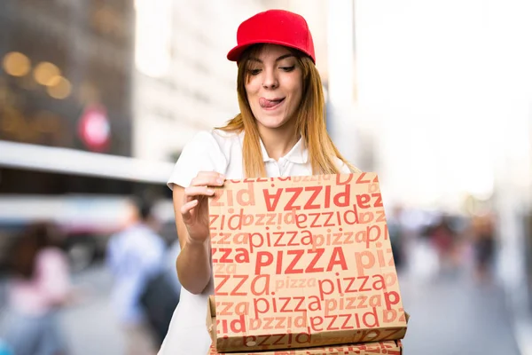 Доставка пиццы женщина на несосредоточенном фоне — стоковое фото