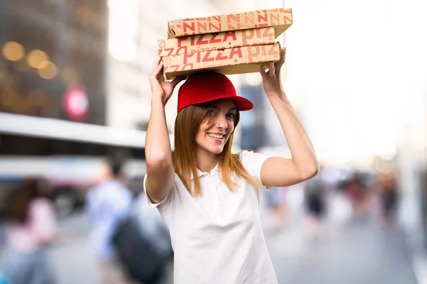 Mujer feliz entrega de pizza en el fondo desenfocado — Foto de Stock