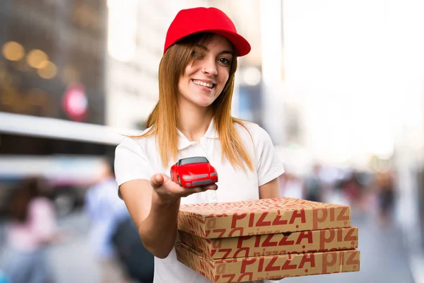 Pizza consegna donna tenendo piccola auto su sfondo sfocato — Foto Stock