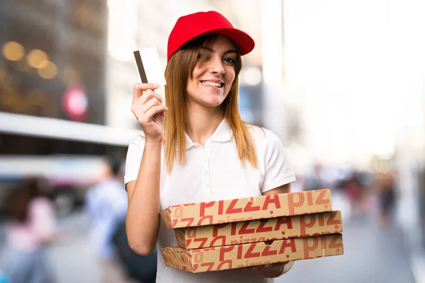 Pizza levering vrouw met een credit card op ongericht backgro — Stockfoto