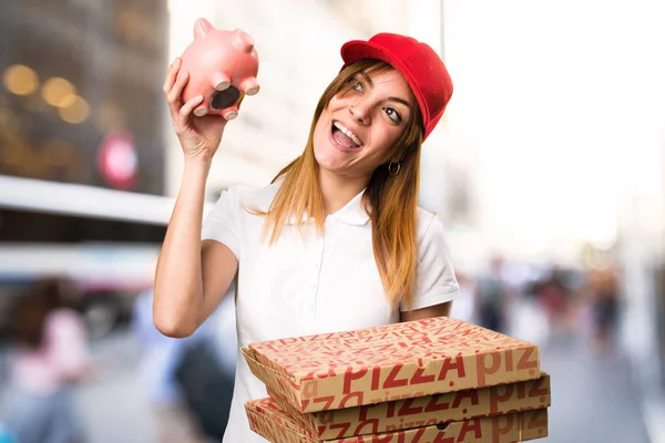 Livraison de pizza femme tenant une tirelire sur backgroun non concentré — Photo