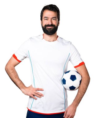 Bir futbol topu tutan mutlu futbolcu
