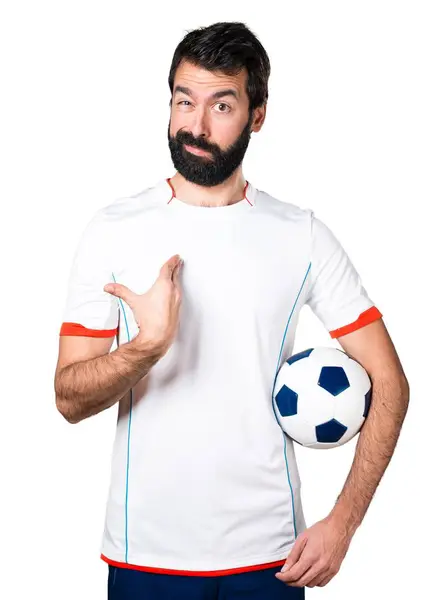 Jogador de futebol segurando uma bola de futebol fazendo gesto surpresa — Fotografia de Stock