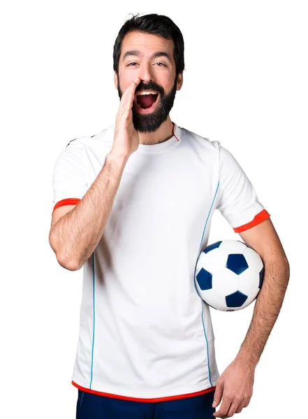 Football player holding a soccer ball shouting — Stock Photo, Image