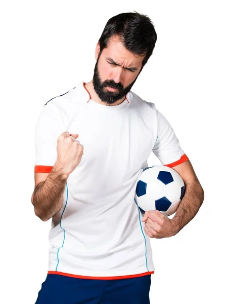 Jugador de fútbol con suerte sosteniendo una pelota de fútbol — Foto de Stock