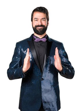 Bir şey tutan payet ceket ile yakışıklı adam