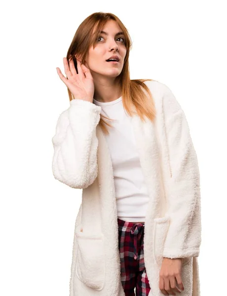 Mujer joven en bata escuchando algo —  Fotos de Stock