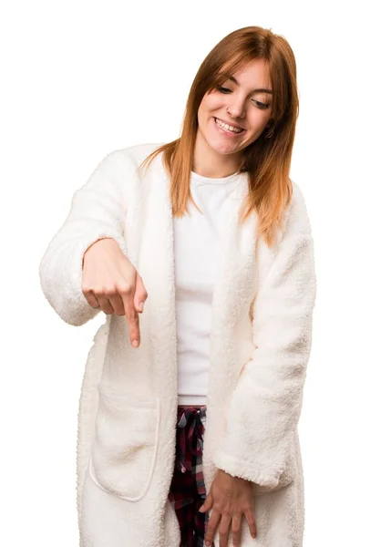 Молодая женщина в халате указывает вниз — стоковое фото
