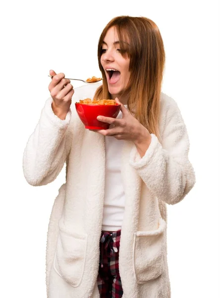 Fiatal nő a pongyola, étkezési gabona, egy tál — Stock Fotó