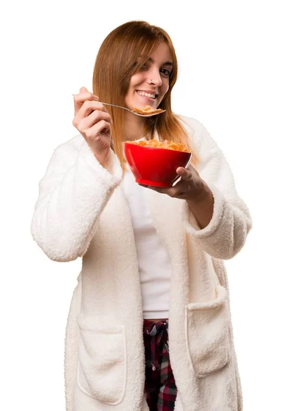 Молодая женщина в халате ест злаки из миски — стоковое фото