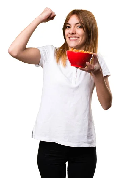 Jovem bonita feliz comendo cereais de uma tigela — Fotografia de Stock