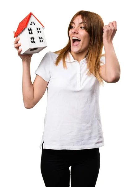 Surprised Beautiful young girl holding a little house — Stock Photo, Image