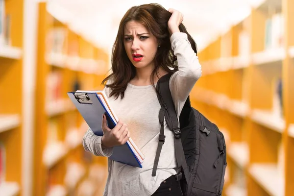 Femme étudiante frustrée dans une bibliothèque — Photo