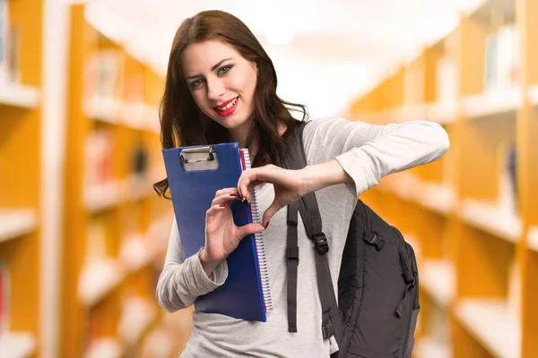 学生女人用她的双手一颗心在图书馆 — 图库照片