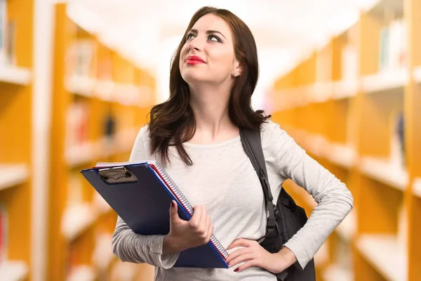 Student vrouw opzoeken in een bibliotheek — Stockfoto