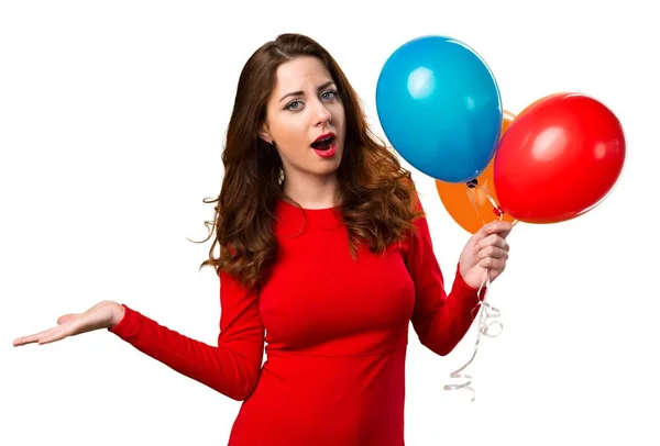 Hermosa joven sosteniendo globos y haciendo gesto sin importancia — Foto de Stock