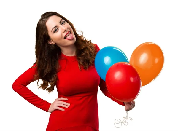 Hermosa joven sosteniendo globos y sacando su lengua — Foto de Stock