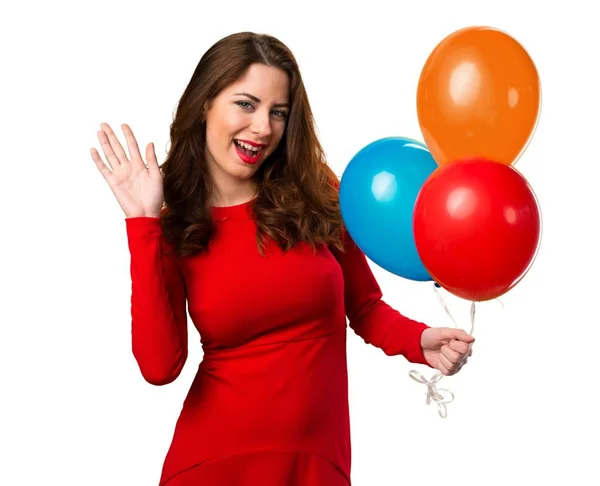 Hermosa joven sosteniendo globos y saludando — Foto de Stock