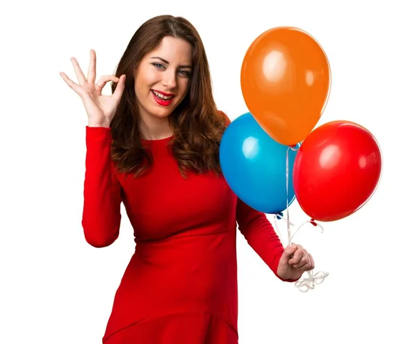 Schöne junge Mädchen hält Luftballons und macht ok Zeichen — Stockfoto