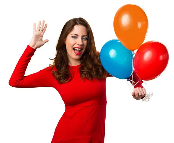 Hermosa joven sosteniendo globos y haciendo gesto sorpresa — Foto de Stock