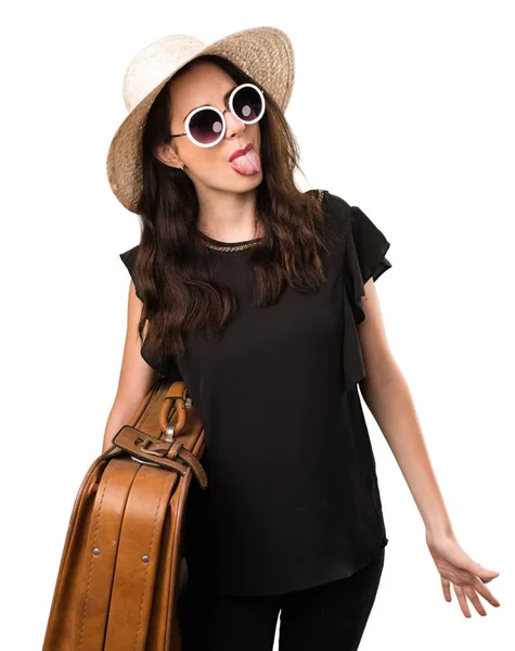 Menina bonita com uma mala tirando a língua — Fotografia de Stock
