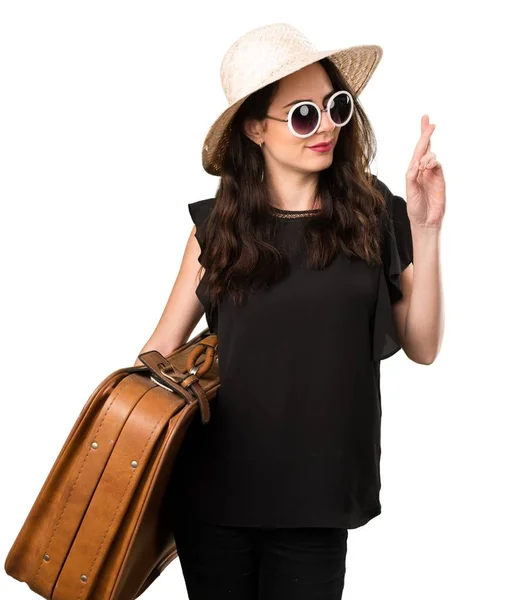 Hermosa joven con una maleta con los dedos cruzados —  Fotos de Stock