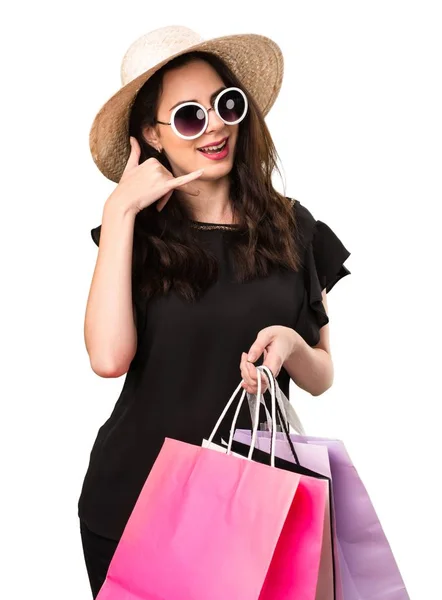 Menina bonita com saco de compras fazendo gesto telefone — Fotografia de Stock