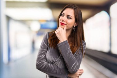 Güzel genç kız odaklanmamış arka plan üzerinde düşünme