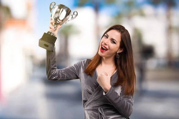 Bella ragazza in possesso di un trofeo su sfondo sfocato — Foto Stock