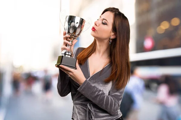 Bella ragazza in possesso di un trofeo su sfondo sfocato — Foto Stock
