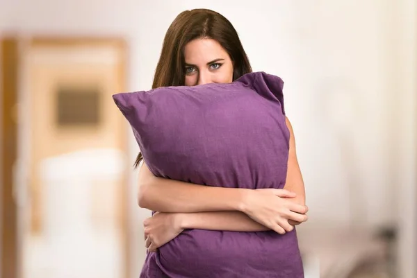 Красивая молодая девушка с подушкой в квартире — стоковое фото