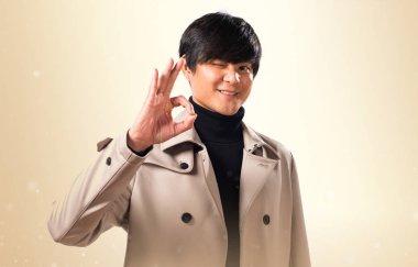 Asya yakışıklı adam Tamam koyu sarı zemin üzerine kayıt yapma