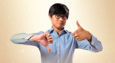 İyi-kötü işaret okra ba yapma gözlüklü Asyalı yakışıklı adam