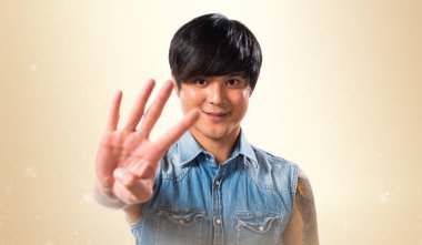 Asya yakışıklı adam dört koyu sarı zemin üzerine sayma