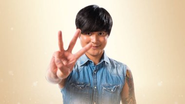 Asya yakışıklı adam üç koyu sarı zemin üzerine sayma