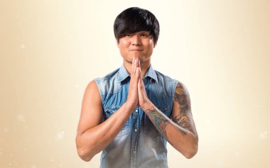 Koyu sarı zemin üzerine yalvaran Asya yakışıklı adam