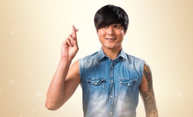 Koyu sarı arka plan üzerinde geçiş parmaklarıyla Asya yakışıklı adam