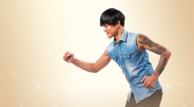 Hızlı koyu sarı arka plan üzerinde koşan Asya yakışıklı adam